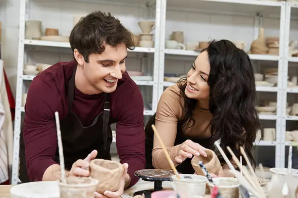 Loving partners shaping clay and sharing laughter in a bright workshop. — Stock Photo