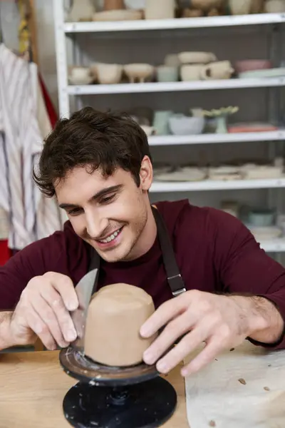 Sophisticated merry man in apron making some pottery in studio. — Stock Photo
