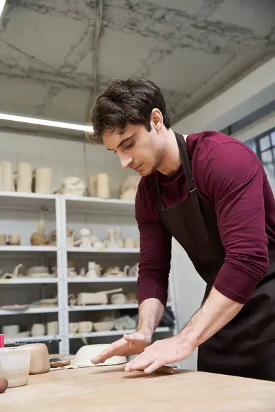 Elegant ambitious man in apron making some pottery in studio. — Stock Photo