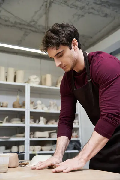 Elegant devoted man in apron making some pottery in studio. — Stock Photo