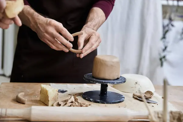 Sophisticated male in apron making some pottery in studio. — Stock Photo