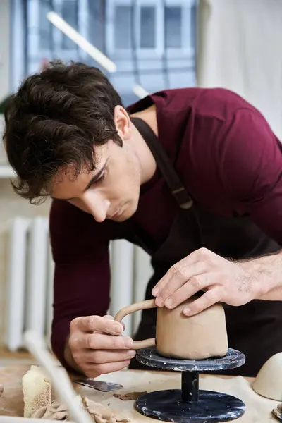 Verführerischer Mann in Schürze töpfert im Atelier. — Stockfoto