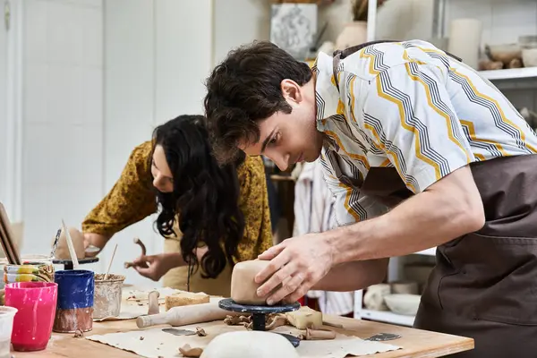 A loving couple molds clay, sharing joy and creativity in a bright studio. — Stock Photo