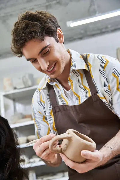 Hombre haciendo cerámica delante de la mujer. - foto de stock