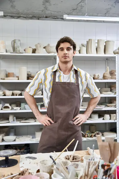 Handsome man in apron in pottery studio. — Stock Photo