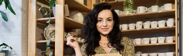 Good looking brunette woman posing in pottery studio. — Stock Photo