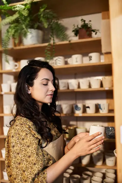 Dedicated brunette woman posing in pottery studio. — Stock Photo