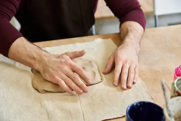 Dedicated man in apron making some pottery in well lit studio. — Stock Photo