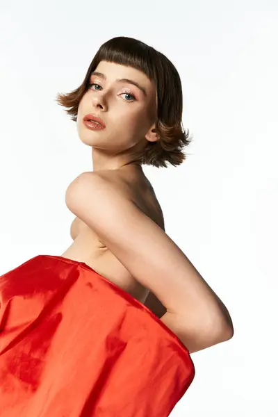 A young woman showcases her beauty in a vibrant red dress adorned with a bow. — Stock Photo
