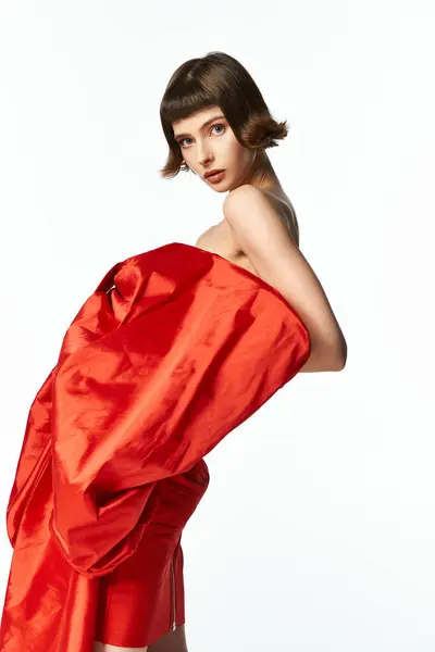 A stylish model captivates with her striking red dress and short hair. — Stock Photo