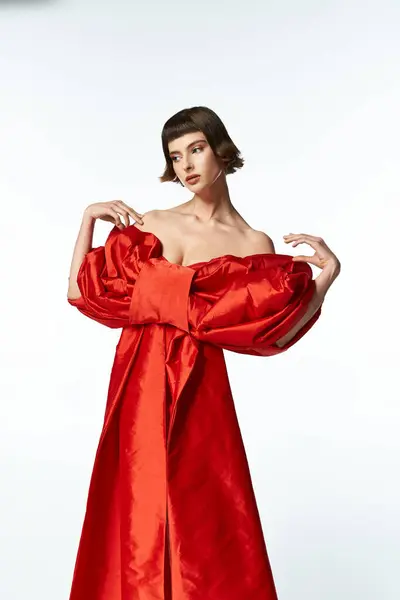 A stylish woman showcases her vibrant red dress with an eye catching bow. — Stock Photo