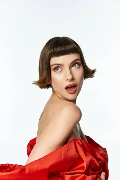 A stylish young woman showcases her red dress with a large bow in a chic pose. — Stock Photo