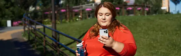 A vibrant woman connects with her fitness routine in the park. — Stock Photo