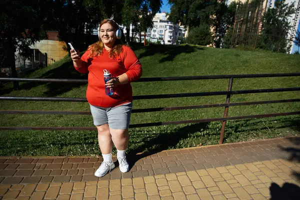 Радостная женщина упражняется на открытом воздухе, слушая музыку. — стоковое фото