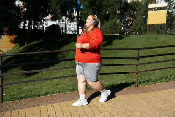A joyful woman exercises outdoors, enjoying her fitness journey. — Stock Photo