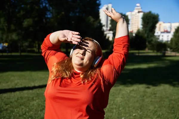 A joyful plus size woman is exercising outdoors in the park. — Stock Photo