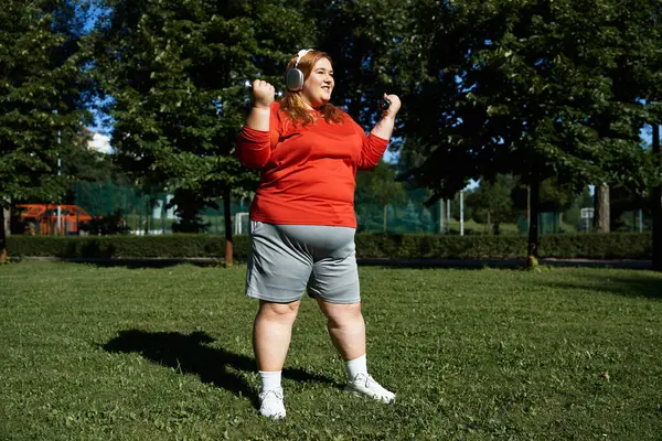 Una mujer alegre se ejercita al aire libre, abrazando la aptitud en un parque vibrante. - foto de stock