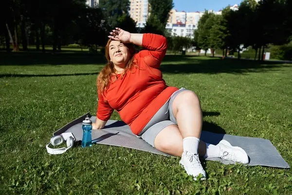 Una donna fiduciosa gode la sua sessione di esercizio su un tappeto all'aperto. — Foto stock