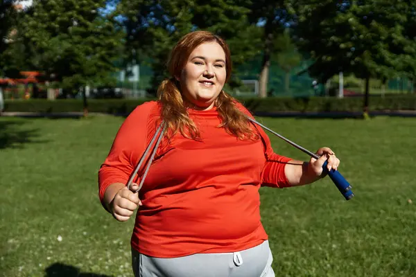 Eine fröhliche Frau treibt in einem sonnigen Park ein lustiges Workout. — Stockfoto