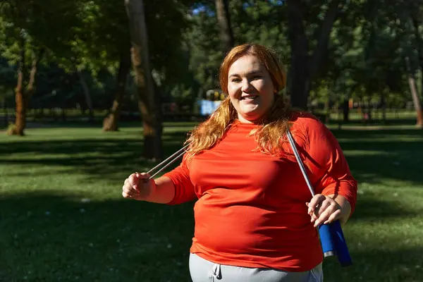 Una donna allegra gode il suo allenamento in un ambiente vivace parco. — Stock Photo