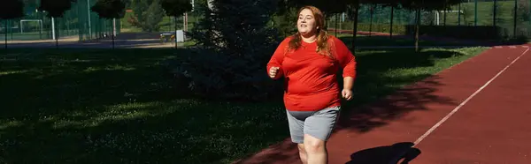 Una donna è felice di correre in un parco lussureggiante sotto la luce del sole. — Foto stock