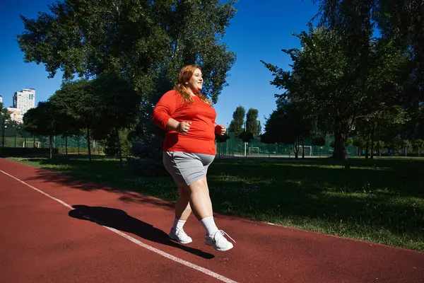 Una donna gioiosa ama correre in un parco soleggiato. — Foto stock