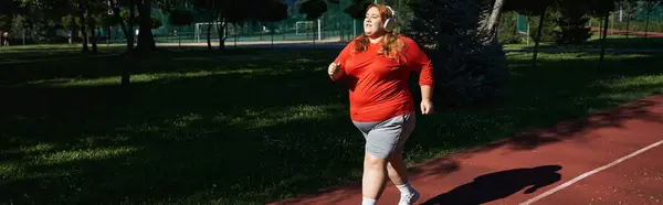 A confident woman enjoys her outdoor workout while jogging along a park path. — Stock Photo