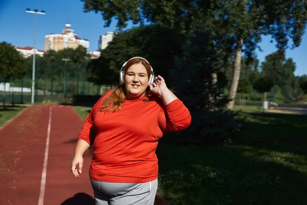 Inspiring plus size woman exercises outdoors, embracing fitness and sunshine. — Stock Photo
