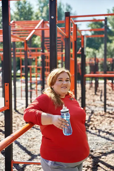 Una donna gioiosa abbraccia il fitness in un vibrante spazio di esercizio all'aperto. — Foto stock