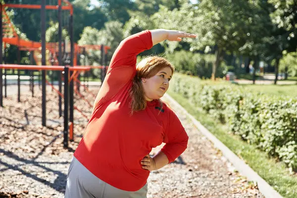 Una donna plus size si impegna in esercizi di stretching all'aperto in un parco. — Foto stock