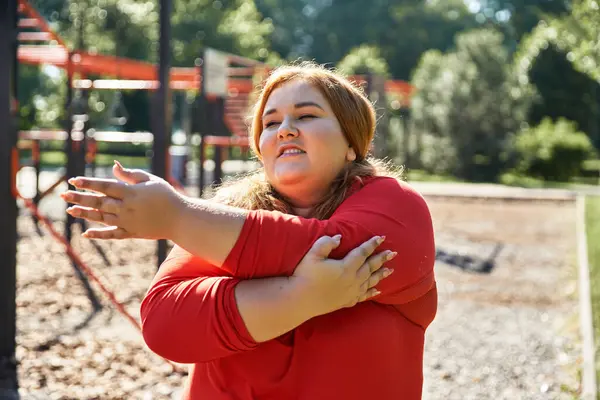 Plus size donna gode la sua routine di fitness durante lo stretching all'aperto. — Foto stock