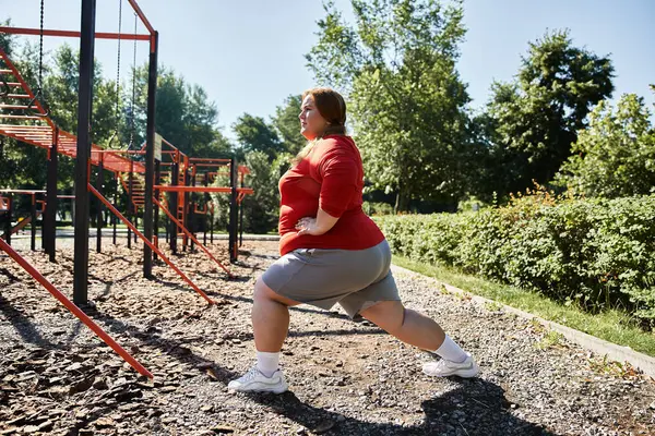 Un gioioso plus size donna esercizi all'aperto, abbracciando l'aria fresca e la bellezza naturale. — Foto stock