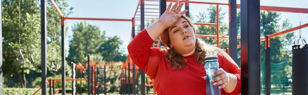 Uma mulher plus size leva um momento para se hidratar após o exercício ao ar livre. — Fotografia de Stock