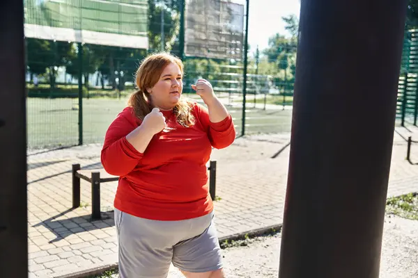 A spirited woman exercises outdoors, embracing fitness and nature with joy. — Stock Photo