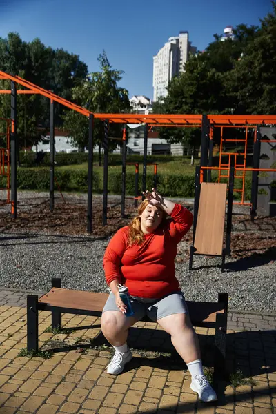 A confident woman takes a break while exercising outdoors on a sunny day. — Stock Photo