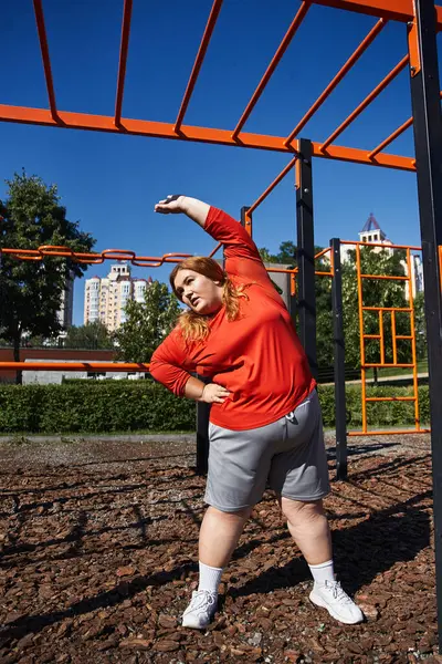 A vibrant woman enjoys an energizing stretch outdoors. — Stock Photo