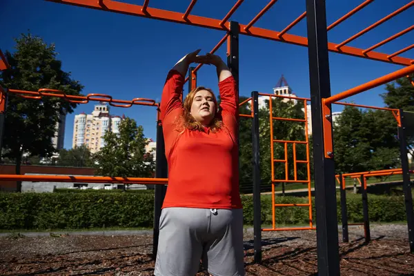 Woman stretches joyfully under clear blue skies in a lively park setting. — Stock Photo