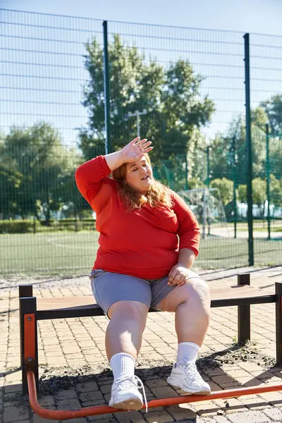 A plus size woman resting after a workout outdoors. — Stock Photo