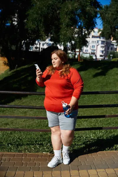 Живая женщина plus-size в активном костюме наслаждается перерывом на тренировки в парке. — стоковое фото
