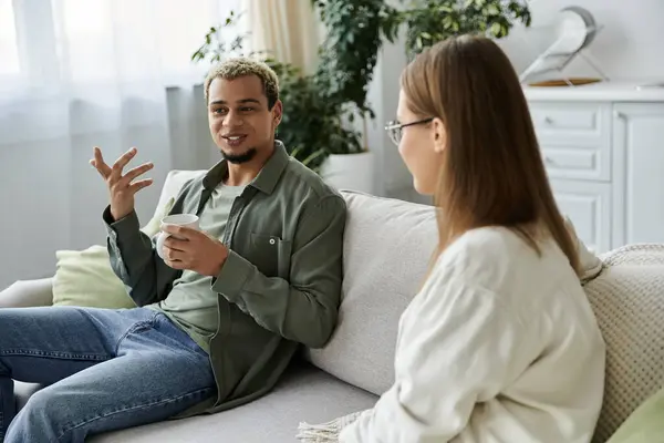 Amigos comparten risas mientras se relajan juntos en un espacio de vida brillante. - foto de stock