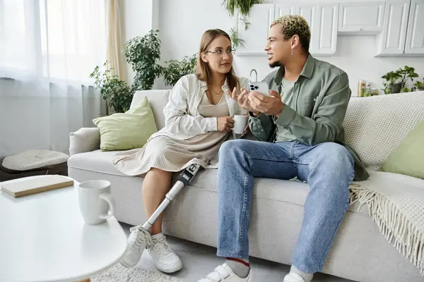 A non binary person and their friend engage in a warm conversation at home. — Stock Photo