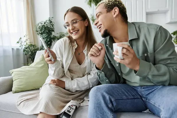 Two friends laugh and share a moment in a stylish, sunlit space. — Stock Photo