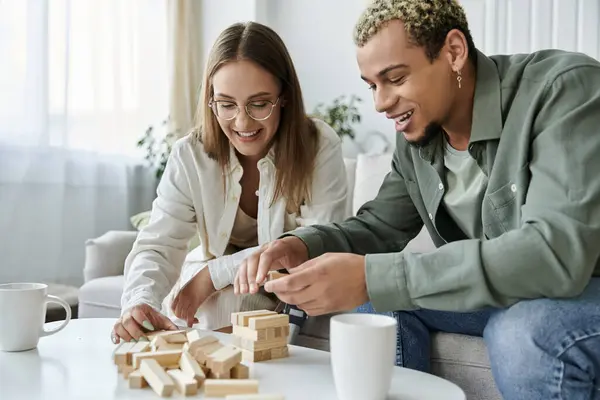 Two friends laughing and playing a game while sharing a cozy moment indoors. — Stock Photo