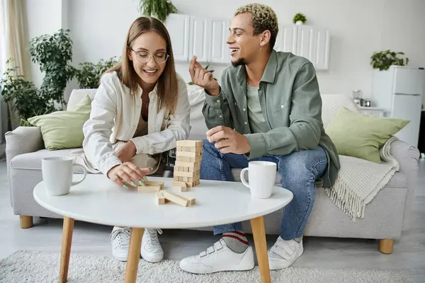 Dois amigos compartilham risos enquanto jogam um jogo juntos dentro de casa. — Fotografia de Stock