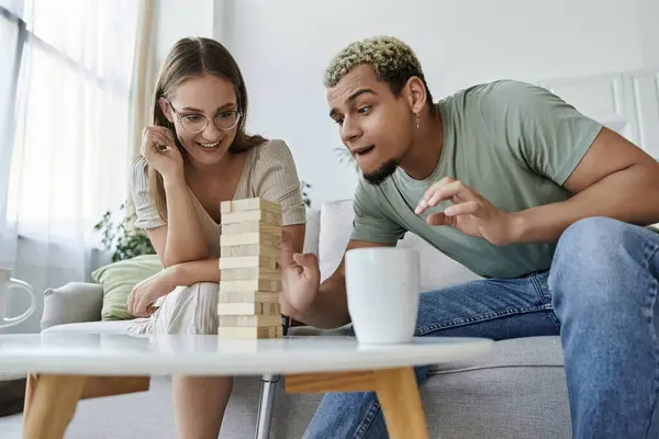 Friends engage in a playful game of Jenga while sharing laughter together. — Stock Photo