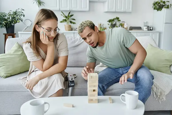 Two friends share laughter while playing a game on a comfortable couch. — Stock Photo