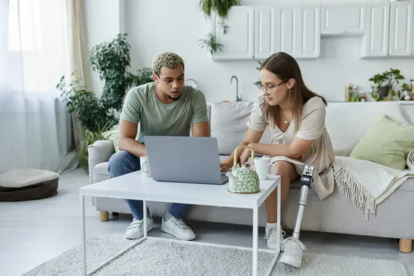 Friends sharing a moment while working on a laptop in a light filled living space. — Stock Photo