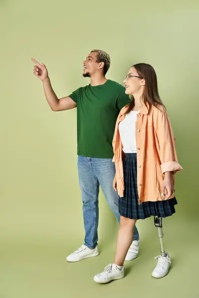 Dos amigos comparten un momento de alegría, señalando algo juntos. - foto de stock