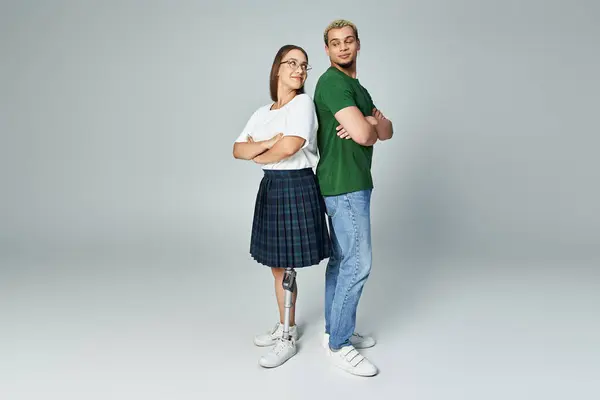Two friends stand back to back, showcasing strength and connection in their unique styles. — Stock Photo