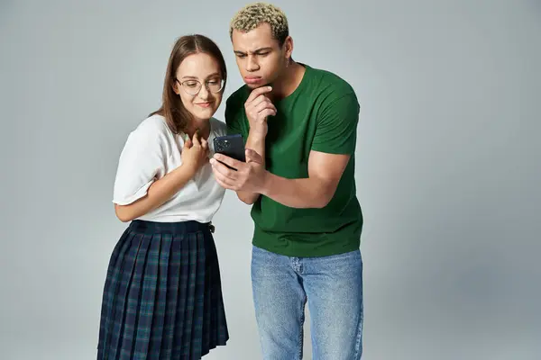 Two friends share a lighthearted moment while looking at a smartphone. — Stock Photo